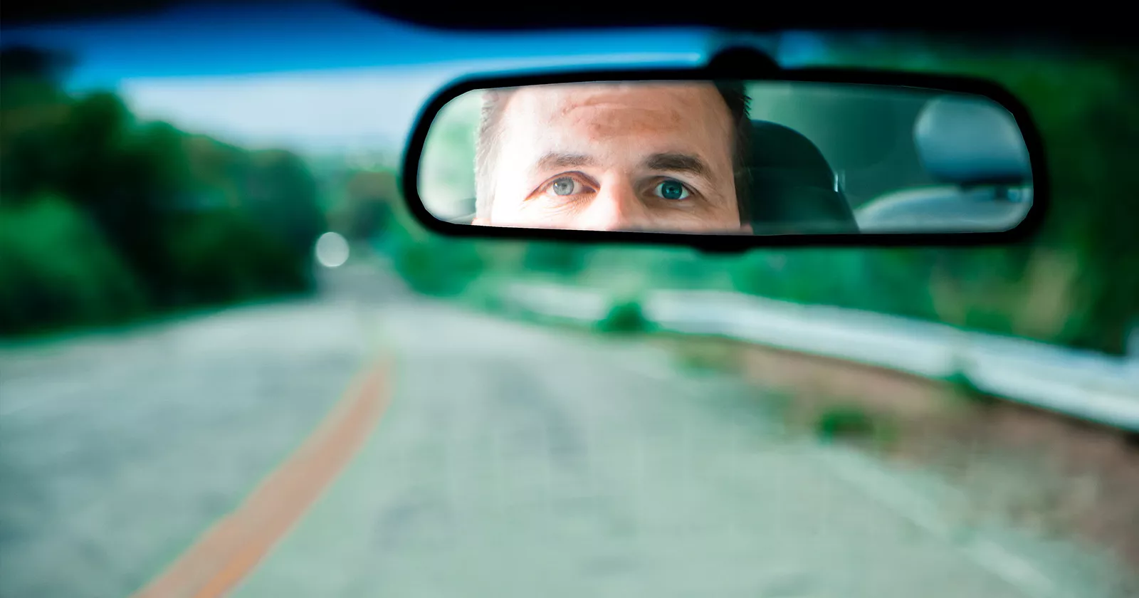 Man driving looking at rearview mirror