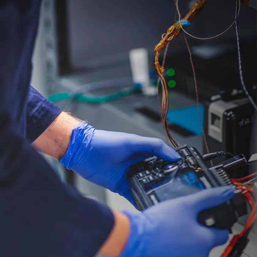 Researcher  tests a consumer electronic product. Exponent scientific and engineering firm helps clients with product safety & recall.