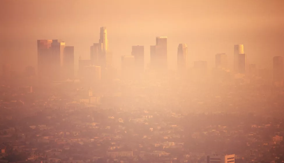 Brown, smoggy, hazy view of cityscape on a hill with skyscrapers  