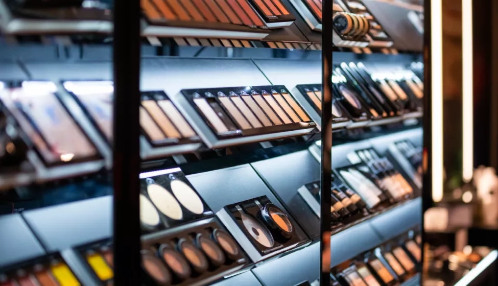 A display shelf in a cosmetic store holding various shades of pressed powders