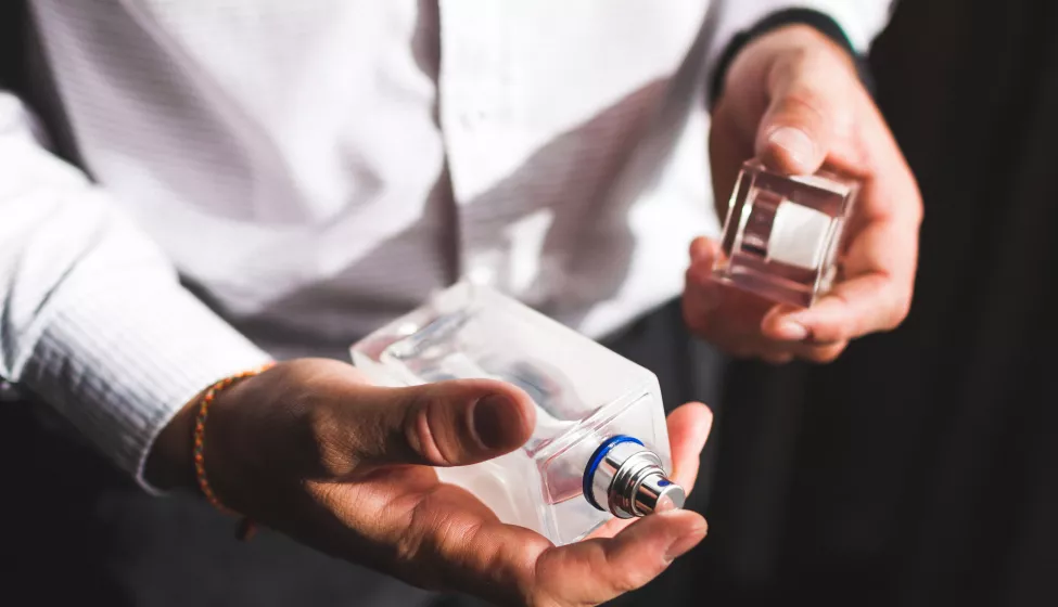 A man spraying a bottle of perfume