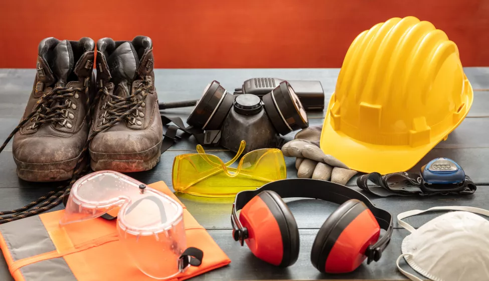 Work safety protection equipment. Industrial protective gear on wooden table