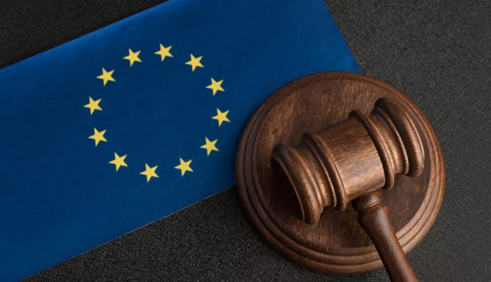 The European flag laid flat next to a gavel