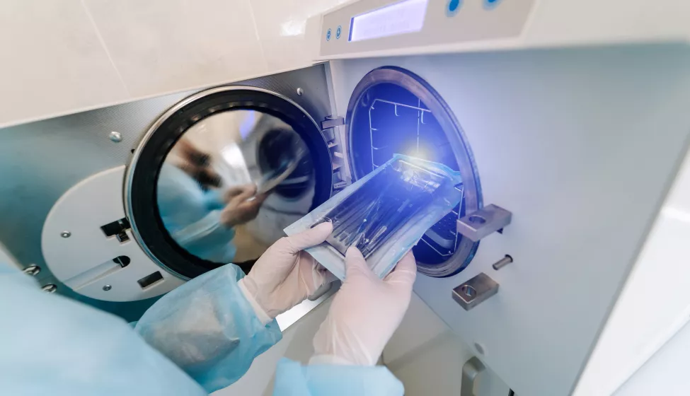 Lab Technician Inserting Sample Test Tube Into A Centrifuge