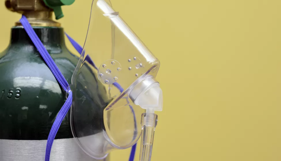 Oxygen Mask Hanging from Medical Oxygen Tank 