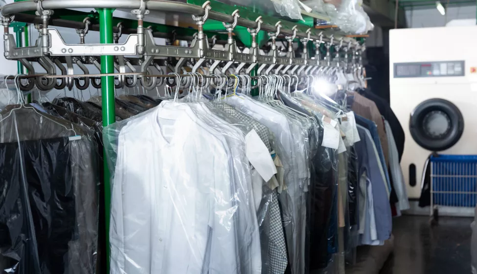 Clothes in plastic bags hanging at dry-cleaning