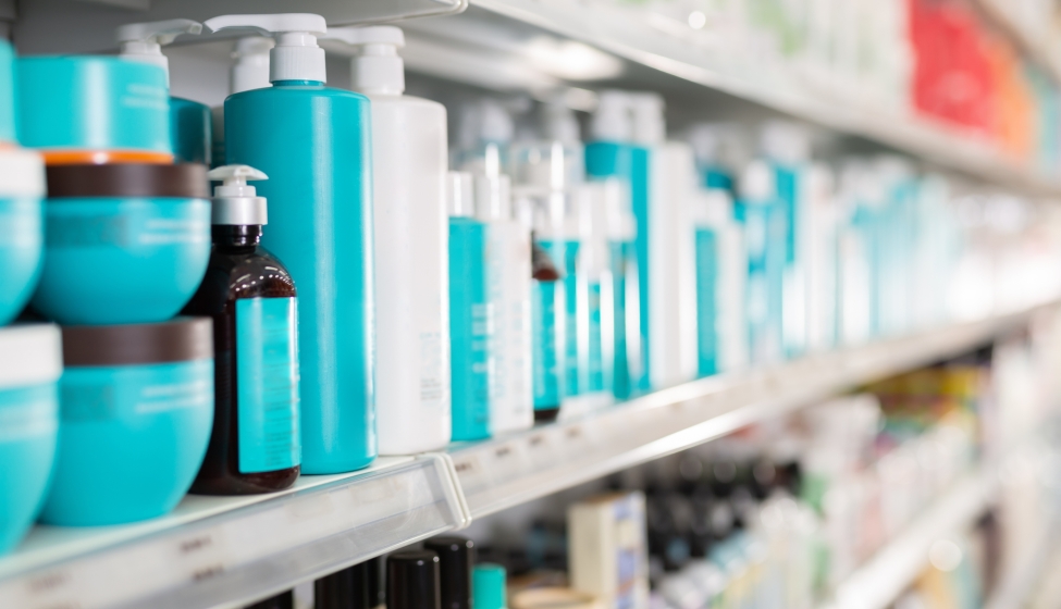 Plastic bottles of various hair care products on shelves of cosmetics store