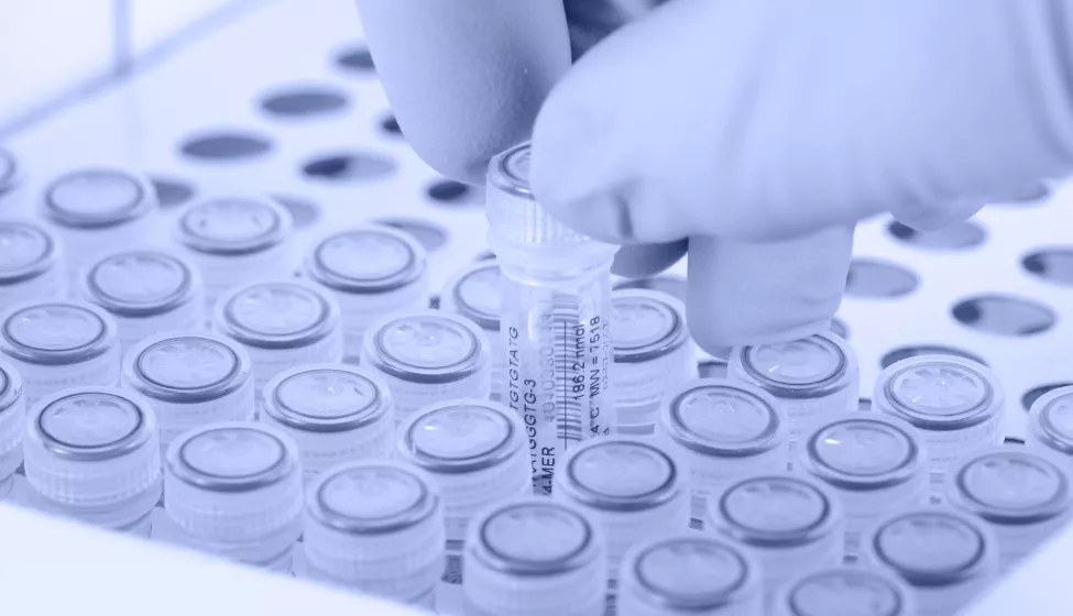 Scientist removes a tube. Gloved hand.