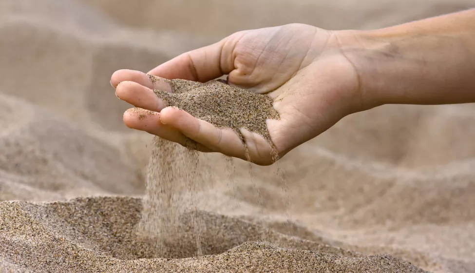 Sand running through fingers