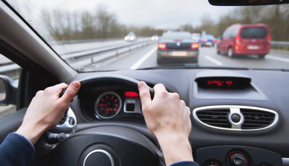 A driver navigating their car on a busy highway. Exponent's vehicle engineers and researchers support innovative driving technologies.