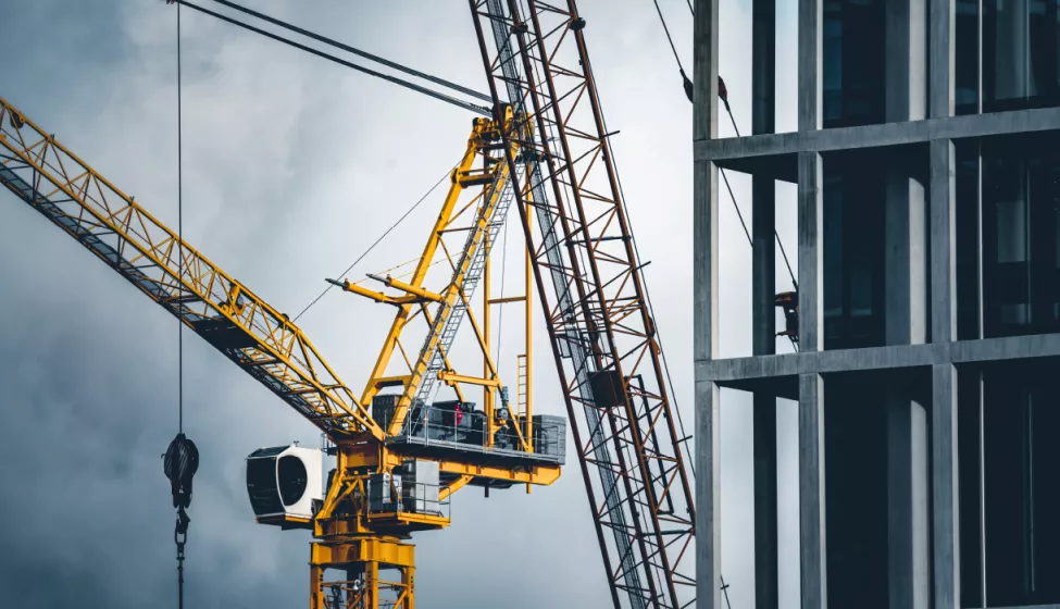 Yellow crane alongside a multi-level building under construction