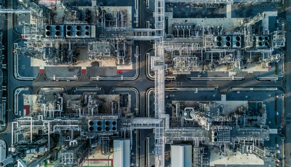 Aerial view of chemical manufacturing plant with smokestacks and piping 