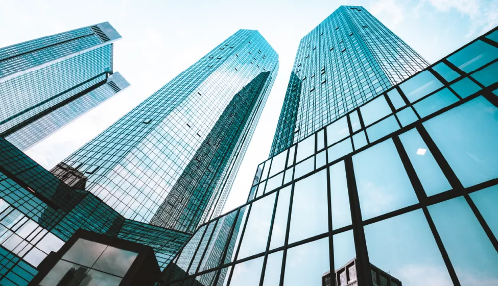 Close up view of glass building sky rise with blue sky above 