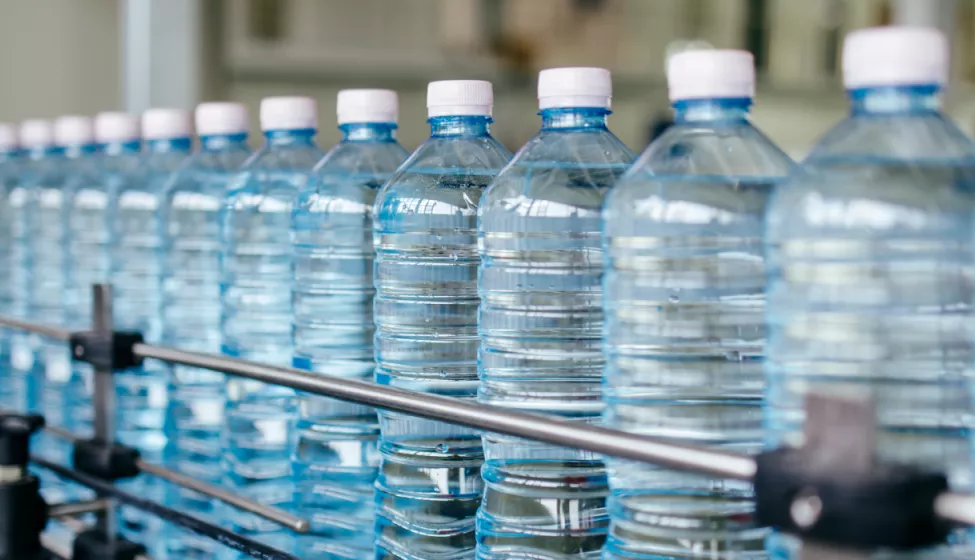 Plastic water bottles moving through a production line.