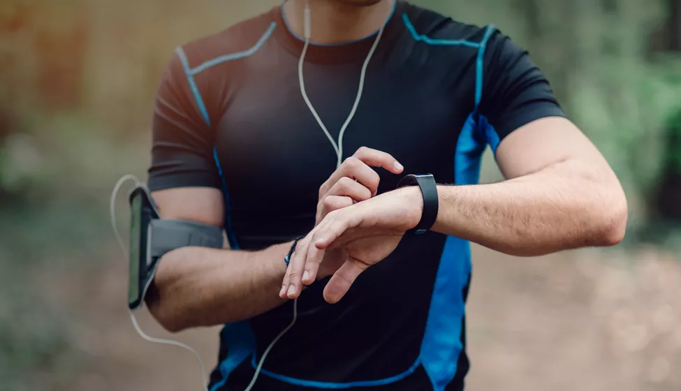 A runner stops to check their smartwatch. Exponent collects real-world evidence and expands data acquisition capabilities to improve healthcare. 