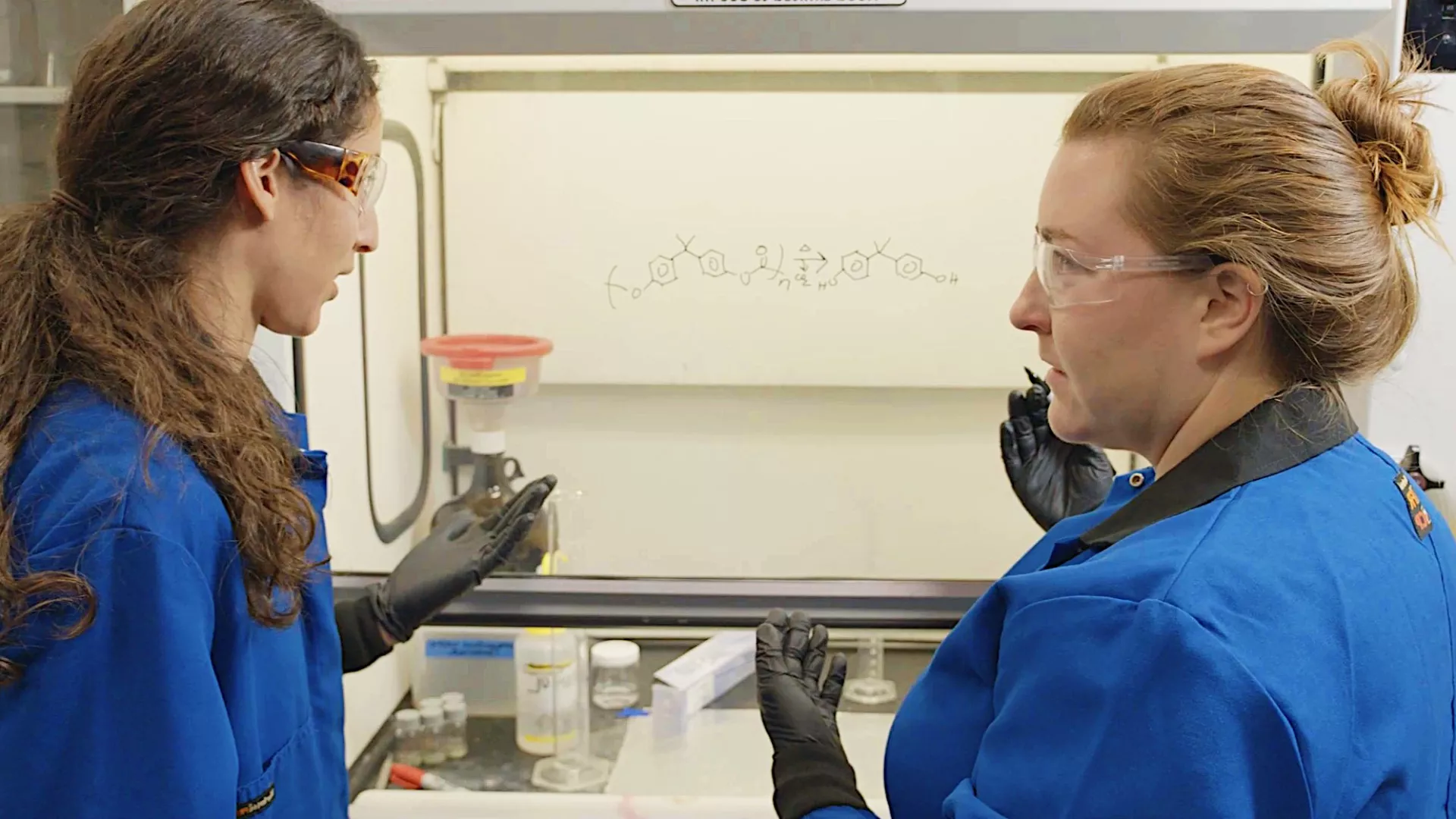 Two Exponent employees discussing a formula in a lab