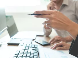 Collegues at a computer. Exponent biomedical experts consult on medical products and regulatory compliance.