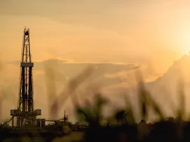 Oil derricks in the sunset and dust. Exponent environmental engineers help clients analyze risk and project costs.