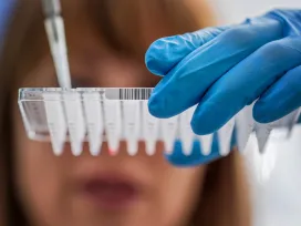 Female scientist working at a laboratory, inspecting a PCR sample tray