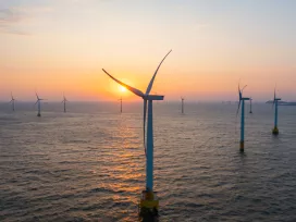 Close-up of wind turbines at sea at sunrise 