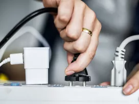A person plugs in multiple electrical chords to a power bar. Exponent performs electrical shock and electrocution assessments.
