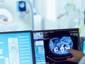 Experts examine internal organ scan on computer screen. Exponent examines medical devices for safety, compliance and resiliency.