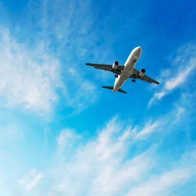 jet airplane landing in bright wispy sky